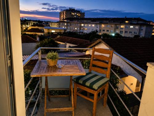a table and chair on a balcony with a view at Sweets Suites Espinho in Espinho
