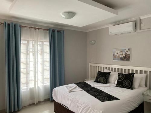 ein Schlafzimmer mit einem Bett und einem Fenster in der Unterkunft The GL in Gaborone