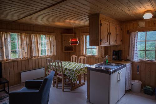 a kitchen and dining room with a table and chairs at Maristuen Fjellferie in Borgund