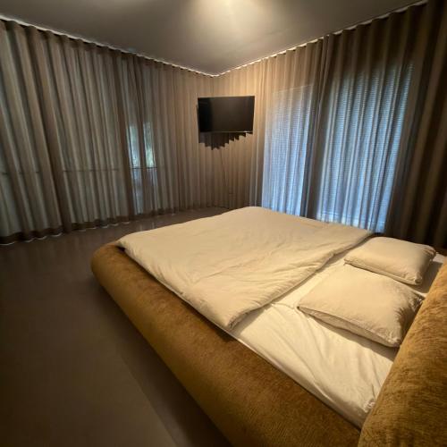 a bedroom with a large bed with a tv on the wall at Orrvägen in Torshälla