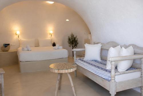 a bedroom with a bed and a couch in a room at SantoCaves in Akrotiri