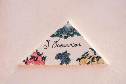 a triangle sign on a wall with fruit on it at I Vacanzieri in Catania
