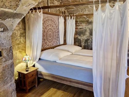 a bed in a room with curtains and a table at Schlossgut Franken in Redwitz an der Rodach