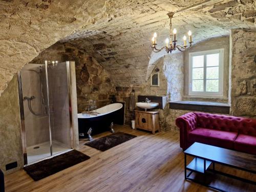 a bathroom with a purple couch and a bath tub at Schlossgut Franken in Redwitz an der Rodach