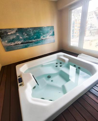 a large bath tub in a room with a window at Tanguero Hotel Boutique Antique in Buenos Aires