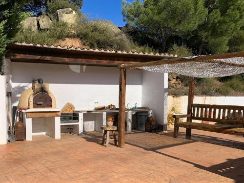 a patio with an outdoor oven and a bench at Cal Catiu in Caserras