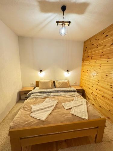 a bedroom with a bed with two towels on it at A&A Durmitor Apartments in Žabljak