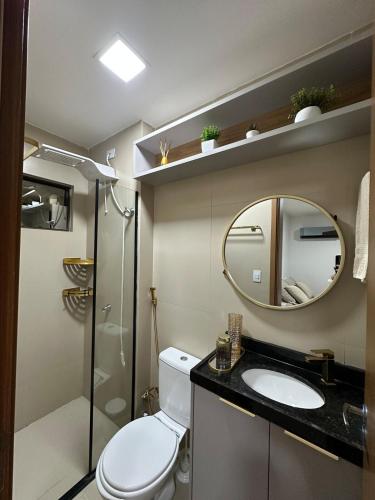 a bathroom with a toilet and a sink and a mirror at Novíssimo Altiplano 3 Quartos e Lazer Completo in João Pessoa
