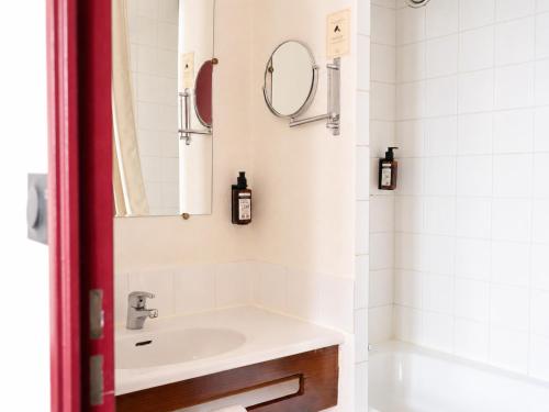 a bathroom with a sink and a mirror at Hôtel Les Trois Luppars in Arras