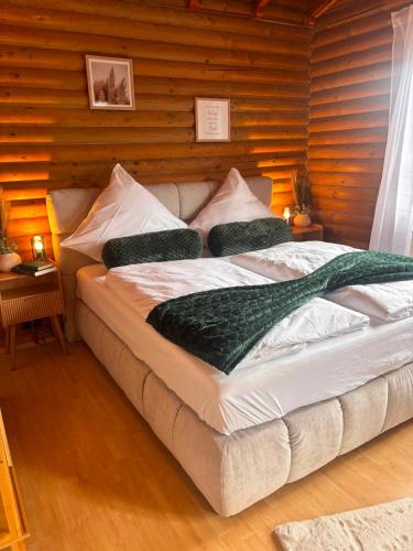 ein großes Bett in einem Zimmer mit Holzwänden in der Unterkunft Westerwald Lodge in Stahlhofen