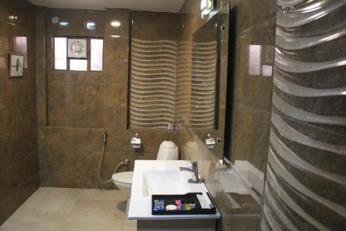 a bathroom with a sink and a toilet at Sarovar Palace in Prayagraj