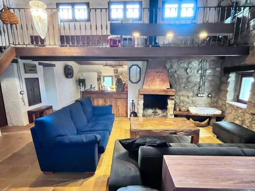 a living room with a blue couch and a fireplace at Cal Catiu in Caserras