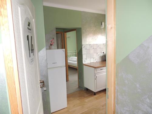 a kitchen with a refrigerator and a room with a bed at Premont Studios Ghimbav in Ghimbav