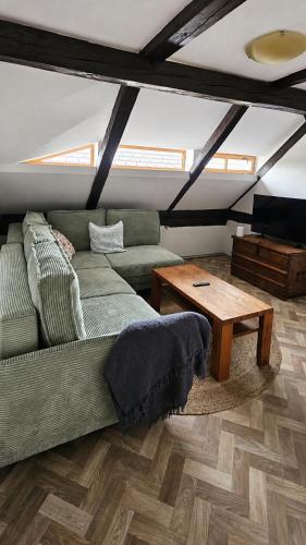 a living room with a green couch and a table at Rustic House v Lužických horách in Jiřetín pod Jedlovou