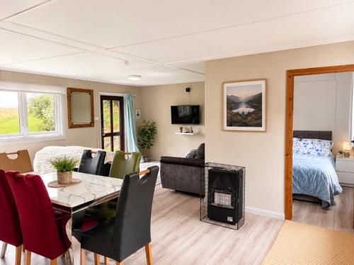 a living room with a table and a room with a bed at John D's Cabin Getaway in Derry Londonderry