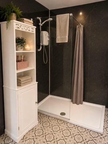 a bathroom with a shower with a white cabinet at John D's Cabin Getaway in Derry Londonderry
