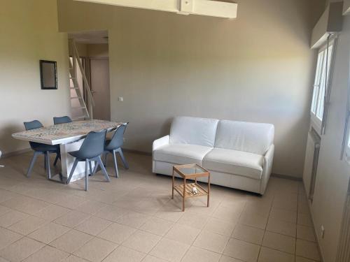 a living room with a couch and a table and chairs at Calme en vacances in Urrugne