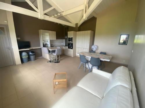 a living room with a white couch and a table at Calme en vacances in Urrugne
