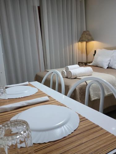 a room with two beds and two tables with white plates at Quarto suíte privativo acesso independente in Genuino Sampaio