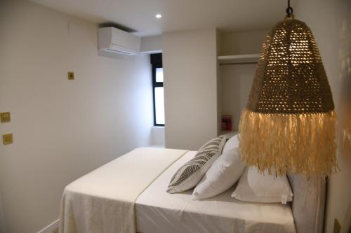 a bedroom with a bed with a chandelier at Amber Apartments in Jávea