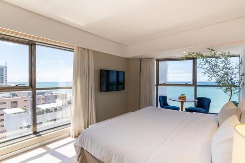 a bedroom with a bed and a large window at HY BEACH FLATS - INTERNATIONAL in Recife