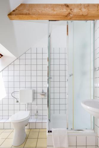 a bathroom with a toilet and a glass shower at Bałtyk Resort in Rewal