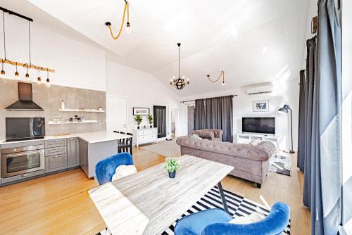 a kitchen and living room with a table and chairs at Sunset Luxury Beach Apartment - Private Pool in Ivan Dolac