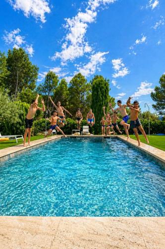 a group of people jumping into a swimming pool at Carrasca 8 paddle & pool in Alcoy