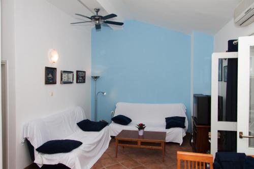 a living room with two white chairs and a ceiling fan at Apartments Sundance in Okrug Donji