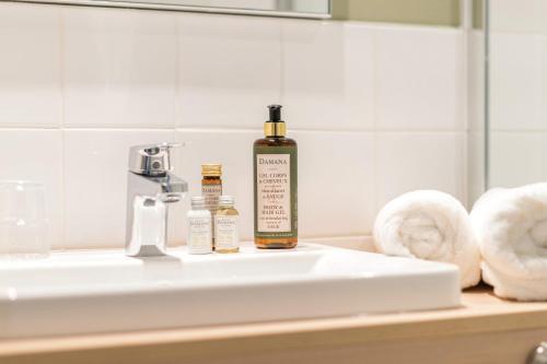 a bottle of alcohol sitting on a bathroom sink at Bikube Coliving Hôtel - Montpellier Centre Gare St Roch in Montpellier