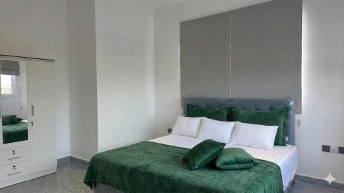 a bedroom with a bed with green sheets and pillows at The Harmony Mount Lavinia in Dehiwala