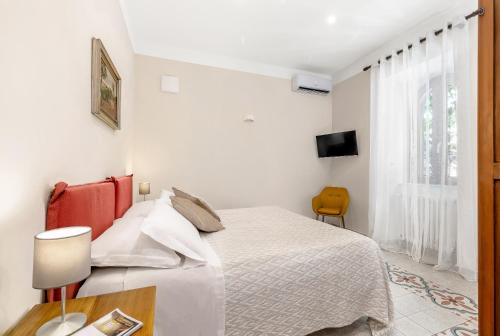 a white bedroom with a bed and a window at TorripaCollection - Villa Livia - Bolsena Lake in Montefiascone