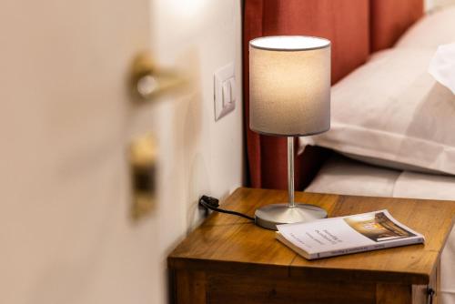 a lamp sitting on a table next to a bed at TorripaCollection - Villa Livia - Bolsena Lake in Montefiascone