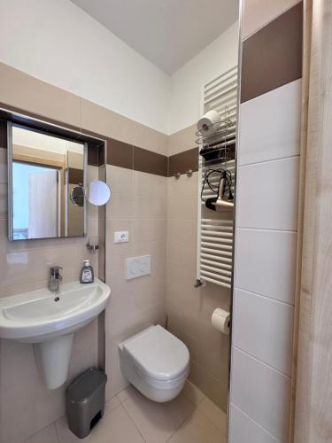 a bathroom with a white toilet and a sink at Terrazza sul Lago in Riva del Garda