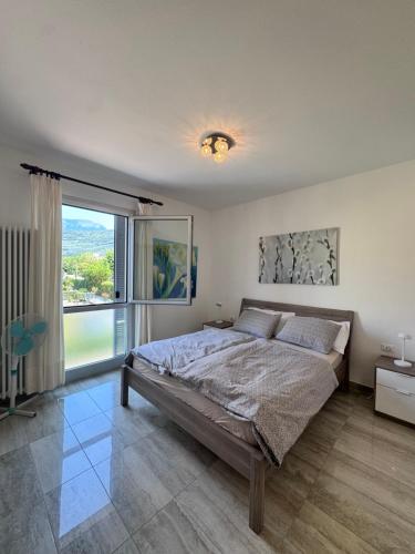 a bedroom with a large bed and a large window at Terrazza sul Lago in Riva del Garda