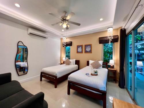 a living room with two beds and a couch at The Snug & The Sierra Airportel in Nai Yang Beach