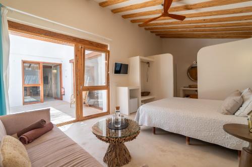 a bedroom with a bed and a couch and a table at Boho Suites Denia in Denia