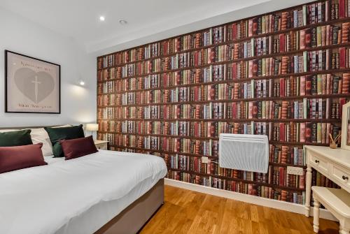 a bedroom with a large wall of dvds at Newly Reopened, Modern Flat Central Location in Staines