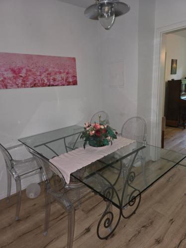 a glass table with a vase of flowers on it at Zimmer im Oldenburger Dobbenviertel in Oldenburg