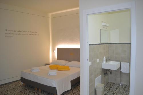 a bedroom with a bed and a sink and a mirror at Sa Domo e tzia Caterina in Orgosolo