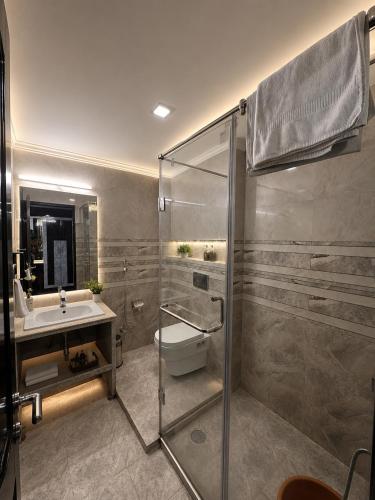 a bathroom with a shower and a toilet and a sink at The Zinnia Castle- Dharamshala # Centrally Heated & Air Cooled # Premium Rooms # Lift # Bar # Terrace # Big Parking # Near market # Top Rated # Property of the year in Dharamshala