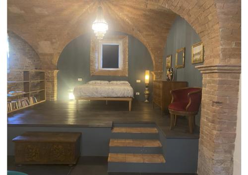 a bedroom with a bed and a chair in a room at Casa Del Principe in Gambassi Terme