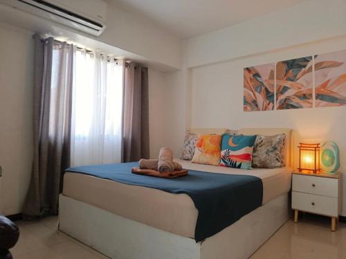 a bedroom with a bed with a blue blanket at Affordable Travellers Studio Condo near Mactan Airport by A&C in Pusok