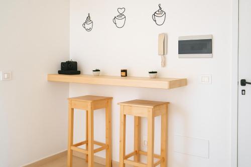 a counter with two wooden stools in a room at Océan serinity Santa Maria in Santa Maria