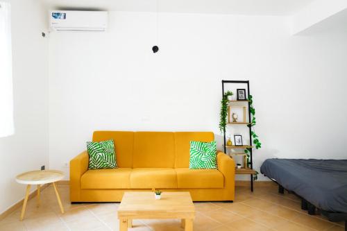 a living room with a yellow couch and a bed at Océan serinity Santa Maria in Santa Maria