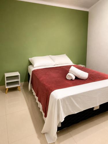 a bedroom with a large bed with a green wall at Apartamento em Condomínio - Centro de Búzios in Búzios