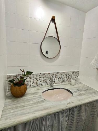 a bathroom sink with a mirror on the wall at Apartamento em Condomínio - Centro de Búzios in Búzios
