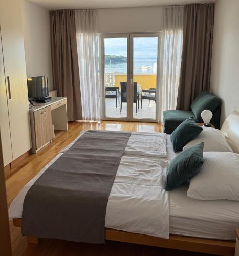 a bedroom with a large bed with a view of the ocean at Villa Ljubica in Pakoštane