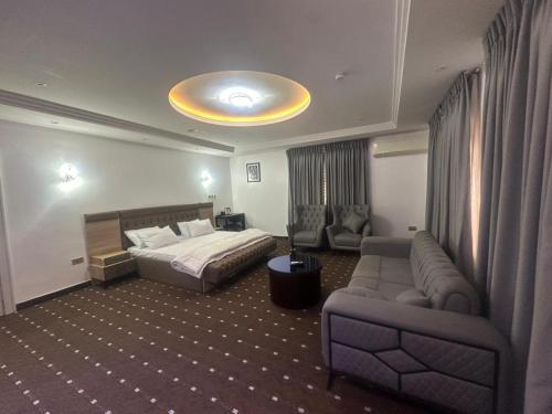a hotel room with a bed and a couch at Peev Apartments in Abuja