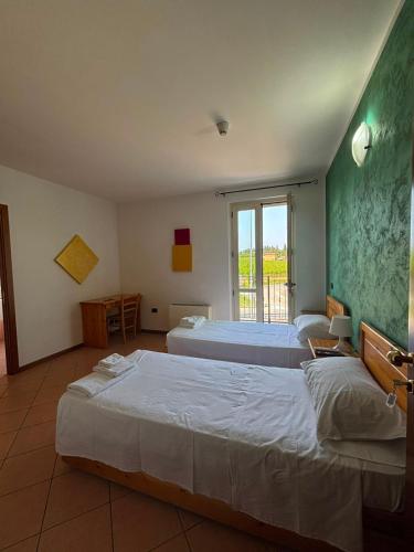 a bedroom with two beds and a window at La Porta del Lugana - Albergo Quattro Pini in Pozzolengo